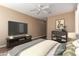 Bedroom with a ceiling fan, a big TV, a picture hanging on the wall, and an area rug at 12957 W Hummingbird Ter, Peoria, AZ 85383