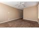 An empty room with wood look floors, ceiling fan, and lots of light from the large windows at 12957 W Hummingbird Ter, Peoria, AZ 85383