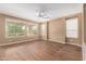 A spacious bedroom offers wood-look tile floors, neutral paint, a ceiling fan and lots of natural light at 12957 W Hummingbird Ter, Peoria, AZ 85383
