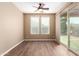 This bedroom has light beige walls, two windows with blinds, ceiling fan, and sliding glass door at 12957 W Hummingbird Ter, Peoria, AZ 85383