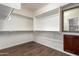 Walk-in closet with wood floors, built-in shelving and a full-length mirror at 12957 W Hummingbird Ter, Peoria, AZ 85383