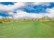 Manicured golf course with green fairways, mature desert vegetation, and blue skies with clouds at 12957 W Hummingbird Ter, Peoria, AZ 85383