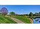 Picturesque golf course with a paved path, mature trees and a tranquil pond at 12957 W Hummingbird Ter, Peoria, AZ 85383