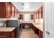 Spacious laundry room boasts wood floors, ample counter space, upper cabinets, and stainless steel washer and dryer at 12957 W Hummingbird Ter, Peoria, AZ 85383