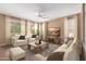 Relax in the cozy living room with comfortable seating, soft curtains, ceiling fan, and a view of the landscaped outdoors at 12957 W Hummingbird Ter, Peoria, AZ 85383