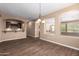 The flowing floorplan with wood-look tile floors and neutral paint enhances the appeal of this open concept living space at 12957 W Hummingbird Ter, Peoria, AZ 85383