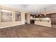 This open-concept living space is enhanced by wood-look tile floors, neutral paint, and lots of natural light at 12957 W Hummingbird Ter, Peoria, AZ 85383