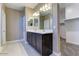Elegant bathroom with a dual sink vanity, bright lighting and tile floors at 13812 W Remuda Dr, Peoria, AZ 85383
