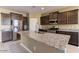 Spacious kitchen features a granite island, stainless steel appliances, and dark wood cabinets at 13812 W Remuda Dr, Peoria, AZ 85383