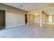 A spacious living space with tile floors, neutral walls, and an open layout leading to dining and hallway areas at 13812 W Remuda Dr, Peoria, AZ 85383