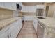 Well-lit kitchen features granite counters, stainless appliances, white cabinetry, and wood-look tile floors at 14161 S Palo Verde Trl, Casa Grande, AZ 85193