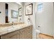 Elegant powder bathroom featuring granite counters, tile floor, and decorative mirror and artwork at 14360 E Desert Cove Ave, Scottsdale, AZ 85259