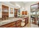 Bathroom featuring granite counters, wooden cabinets, and a large mirror with vanity lighting at 14360 E Desert Cove Ave, Scottsdale, AZ 85259