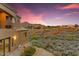 Desert home at dusk featuring a view of the balcony, landscaping, and neighborhood at 14360 E Desert Cove Ave, Scottsdale, AZ 85259