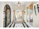 Grand foyer featuring tile floors, columns, and a decorative glass door leading to the living space at 14360 E Desert Cove Ave, Scottsdale, AZ 85259