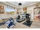 Bright home gym features several workout machines, unique lighting, and a large window with a beautiful desert view at 14360 E Desert Cove Ave, Scottsdale, AZ 85259