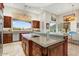 Gourmet kitchen with granite countertops, stainless steel appliances, and a breakfast bar with mountain views at 14360 E Desert Cove Ave, Scottsdale, AZ 85259