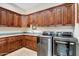 Spacious laundry room with granite countertops, wooden cabinets and modern washer and dryer at 14360 E Desert Cove Ave, Scottsdale, AZ 85259