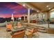 Multi-level outdoor patio featuring a lounge area, bar seating, a fire pit, and dining furniture at 14360 E Desert Cove Ave, Scottsdale, AZ 85259