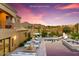 Inviting outdoor living space with pool, spa, lounge seating, and views of the desert landscape at sunset at 14360 E Desert Cove Ave, Scottsdale, AZ 85259