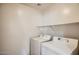 The laundry room boasts a washer, dryer, and storage shelf at 14544 W Sierra St, Surprise, AZ 85379