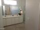 Bathroom boasts dual sinks, a large mirror, and a glass-enclosed shower at 15104 W Pinehurst W Ln, Surprise, AZ 85374