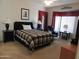 Spacious bedroom with a large window, a comfortable chair, and a black dresser at 15104 W Pinehurst W Ln, Surprise, AZ 85374