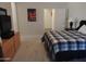 Comfortable bedroom with a plaid comforter, neutral walls, and a view into the bathroom at 15104 W Pinehurst W Ln, Surprise, AZ 85374