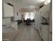 Bright kitchen with tile floor and white cabinets leads to adjacent dining area with large view window at 15104 W Pinehurst W Ln, Surprise, AZ 85374