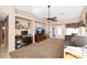 A bright living room with a ceiling fan, French doors, and a cozy layout perfect for relaxation and entertaining at 15412 W Port Royale Ln, Surprise, AZ 85379