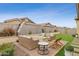 A beautifully designed backyard featuring a cozy lounge area with a fire pit and comfortable seating arrangement at 15998 W Electra Ln, Surprise, AZ 85387