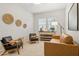 Cozy living room features tan sofa, two chairs, and neutral decor at 15998 W Electra Ln, Surprise, AZ 85387