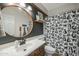 Stylish bathroom with black accent wall, round mirror, and shower with decorative curtain at 18841 E Pelican Ct, Queen Creek, AZ 85142