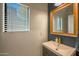 Modern bathroom featuring a sink, square mirror, a window and neutral color palette at 18841 E Pelican Ct, Queen Creek, AZ 85142