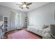 Bright bedroom featuring a ceiling fan, large windows, and neutral color palette with a pink rug at 18841 E Pelican Ct, Queen Creek, AZ 85142