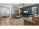 Cozy living room featuring a ceiling fan, a textured accent wall, and hardwood flooring at 18841 E Pelican Ct, Queen Creek, AZ 85142