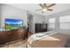 Spacious main bedroom features wood floors, ceiling fan, television, and ensuite bathroom at 18841 E Pelican Ct, Queen Creek, AZ 85142