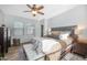 Bright main bedroom with natural light, neutral color palette, ceiling fan, and seating bench at 18841 E Pelican Ct, Queen Creek, AZ 85142