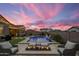 Inviting backyard at dusk with in-ground pool, patio area, grill and fire pit at 20040 E Kestrel St, Queen Creek, AZ 85142