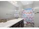Bright bathroom with double sink vanity, decorative tile backsplash, and a rainbow-themed shower curtain at 20040 E Kestrel St, Queen Creek, AZ 85142