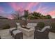 Cozy backyard seating area with stylish stone fire pit, plush seating and patio pavers at 20040 E Kestrel St, Queen Creek, AZ 85142