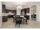Open kitchen with dark cabinets, granite counters, stainless steel appliances, and dining area with island seating at 20040 E Kestrel St, Queen Creek, AZ 85142