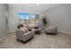 Comfortable living room with tiled floors, large windows providing ample natural light, and cozy seating arrangement at 20040 E Kestrel St, Queen Creek, AZ 85142