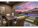 Covered patio dining area overlooking a private pool and lush backyard with stunning sunset views at 20040 E Kestrel St, Queen Creek, AZ 85142