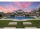 Beautiful in-ground pool surrounded by artificial turf and stone pavers in a fenced backyard at 20040 E Kestrel St, Queen Creek, AZ 85142