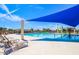 Community swimming pool and splash pad with lounge seating and shade structures under a clear blue sky at 20040 E Kestrel St, Queen Creek, AZ 85142