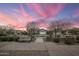 Charming street view of houses with manicured lawns under a vibrant pink sunset sky at 20040 E Kestrel St, Queen Creek, AZ 85142