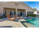 Lush backyard featuring an inviting pool with tanning ledge, covered patio, outdoor seating, and well-maintained landscaping at 20331 N Fletcher Way, Peoria, AZ 85382