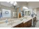 Bright bathroom features dual sinks, large mirror, glass block window and walk-in shower at 20331 N Fletcher Way, Peoria, AZ 85382