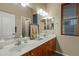 Well-lit bathroom featuring a double vanity with wooden cabinetry and framed mirrors above at 20331 N Fletcher Way, Peoria, AZ 85382